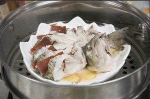 將鱸魚成花狀擺好，將火腿切片放入各縫隙中，放入鍋中隔水蒸12分鐘拿出，撒上蔥花即可。