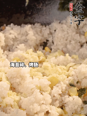 剩米飯下鍋炒散，依次下玉米粒、雞蛋、烤腸、海苔碎翻炒均勻。