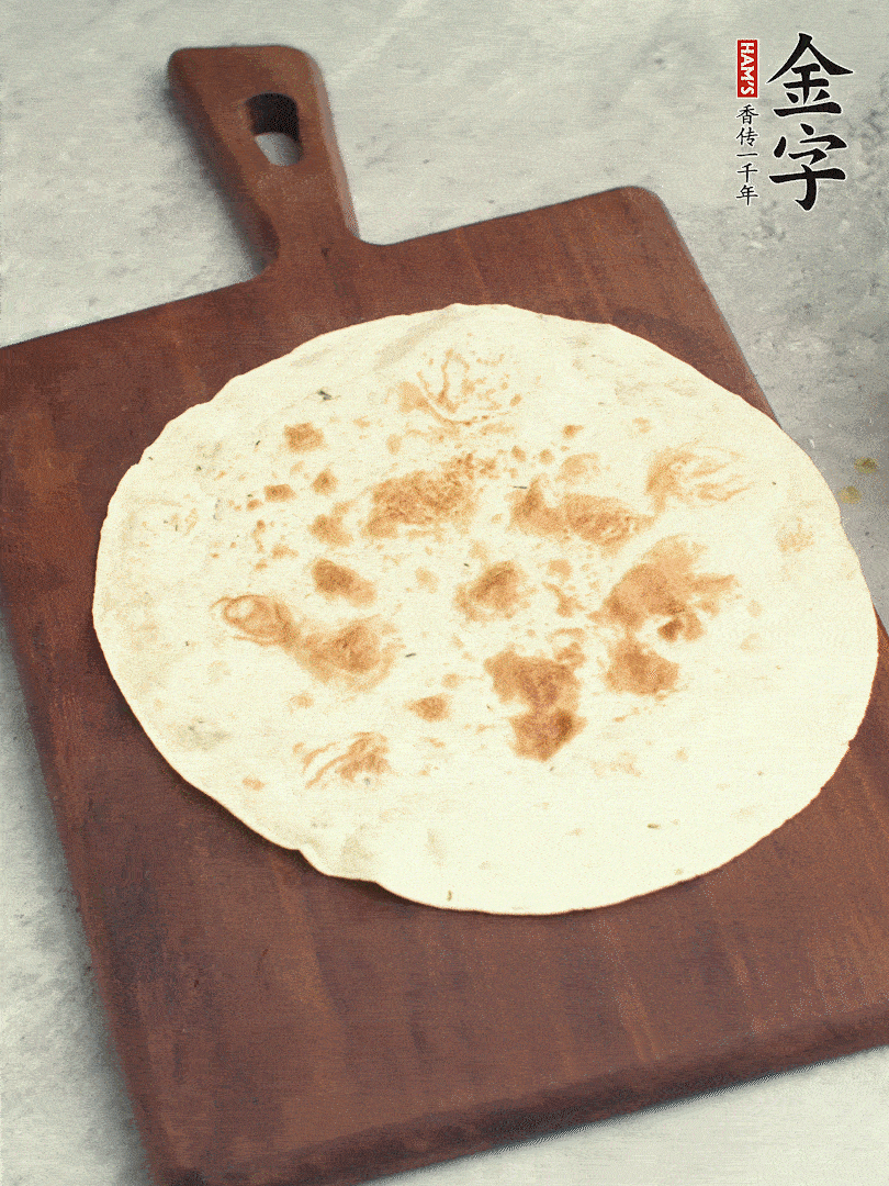 食材依次鋪在卷餅皮上，卷起來。