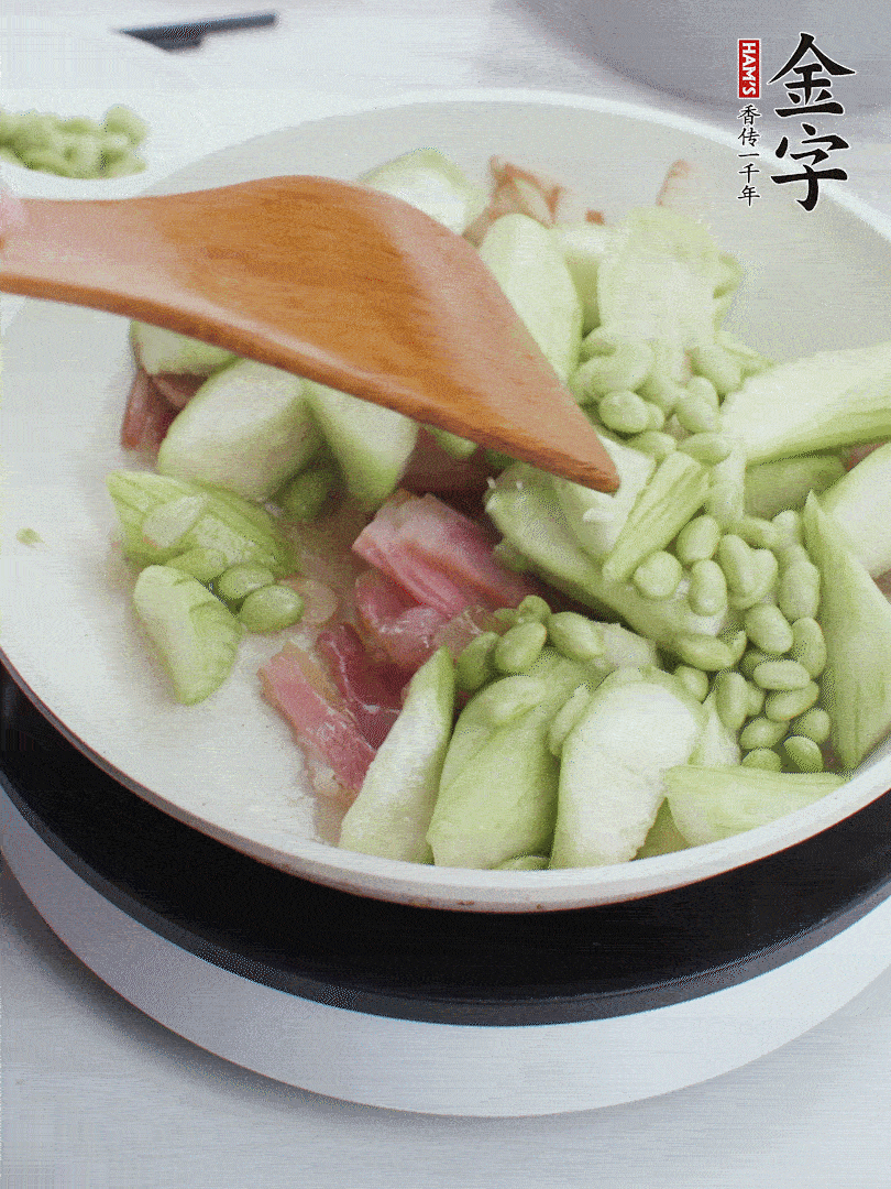 依次下絲瓜、青豆翻炒，炒至絲瓜打蔫縮小。