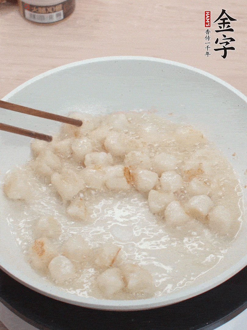 油溫4成熱，鮮貝蘸干淀粉下鍋煎，一面微黃后翻面。