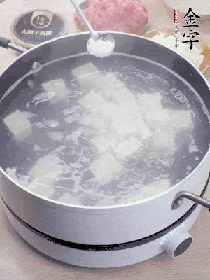 豆腐切成大小均勻正方體，鍋內(nèi)放水，加一點鹽焯水10秒。
