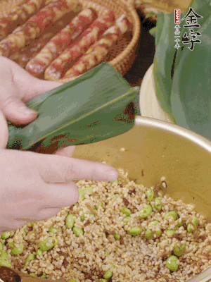 粽葉往下折，完全蓋住，兩側(cè)捏緊。