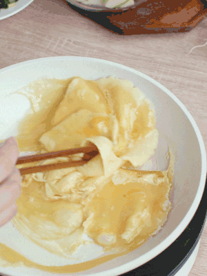 油6成熱時，下雞蛋液，邊緣凝固時翻拌成塊狀。