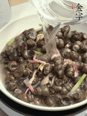 倒處理干凈的螺螄翻炒，加3勺料酒。加清水蓋過螺螄，中火蓋蓋煮5分鐘。