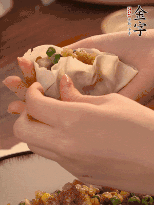 取一大勺餡料放進餃子皮里，用大拇指按住頂部餡料，再用虎口掐出形狀。