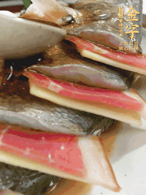 魚肚中塞蔥結(jié)、火腿片，魚身上碼放姜片、火腿片，倒入混合的料汁。