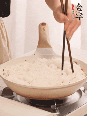 把瀝干水分的米飯均勻鋪在上面，筷子戳幾個洞，以便透氣，轉(zhuǎn)小火蓋上蓋子燜至水分收干，大概10分鐘。
